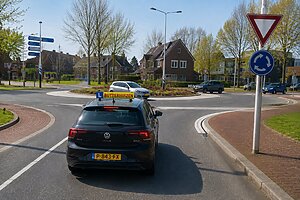 Leerling past tijdens rijles snelheid aan een verkeerssituatie aan