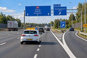 Leerling voegt tijdens rijles veilig in vanaf een invoegstrook op een Nederlandse snelweg